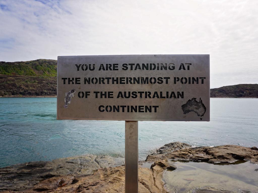 Sign at Cape York, Australia's northernmost point, with the beach in the background