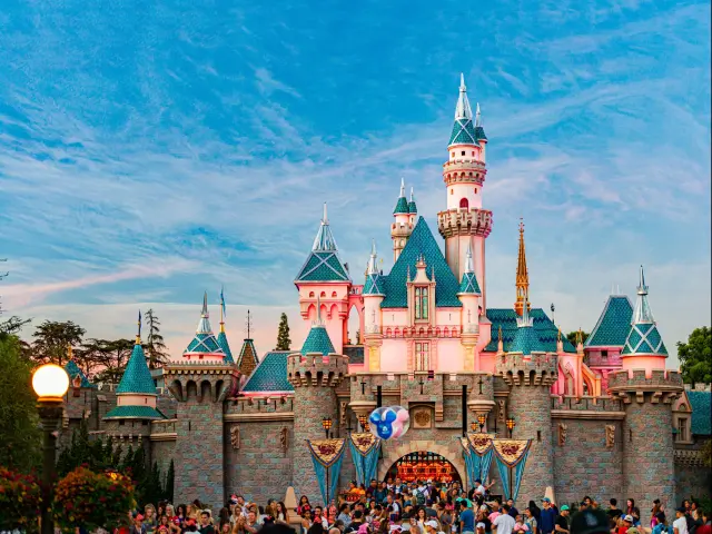 Disney castle of sleeping beauty in Disneyland surrounded by crowds of people