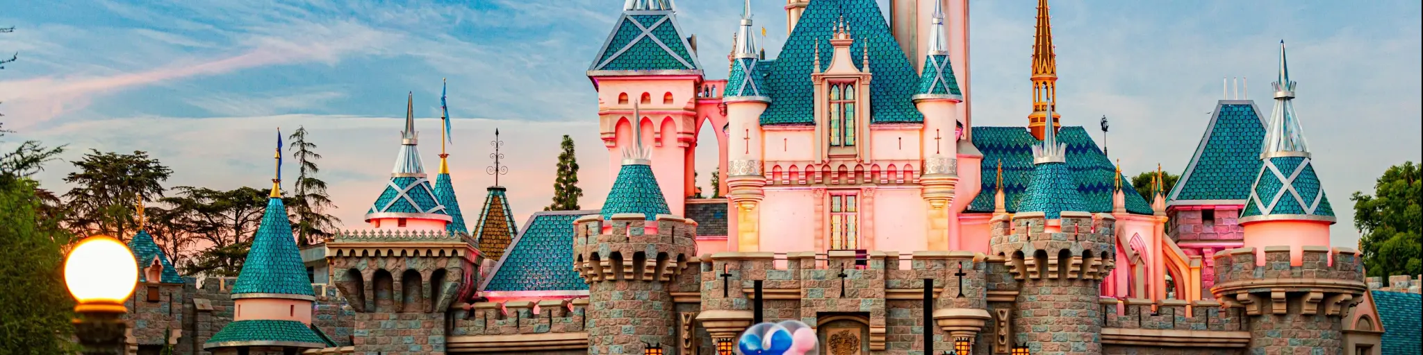 Disney castle of sleeping beauty in Disneyland surrounded by crowds of people