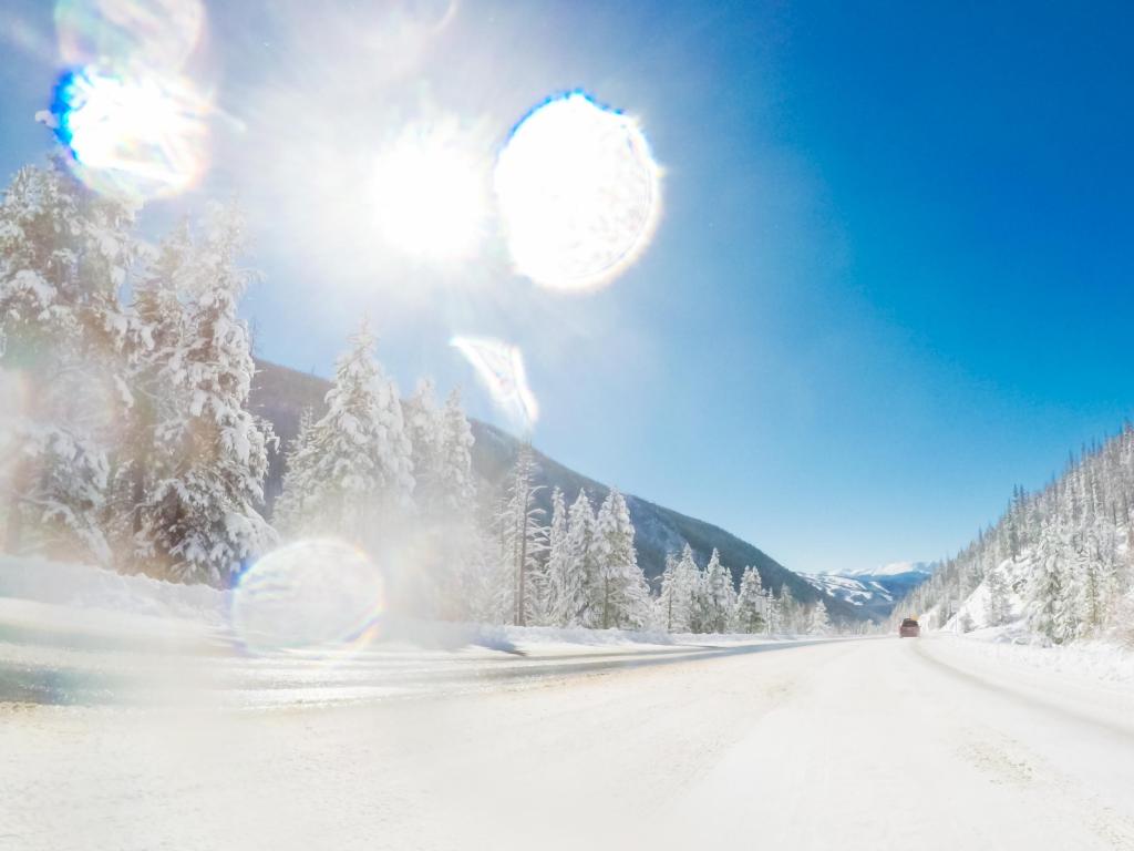 Shot taken from a driver's point of view, driving through a snowy Rocky Mountain road after a snowstorm
