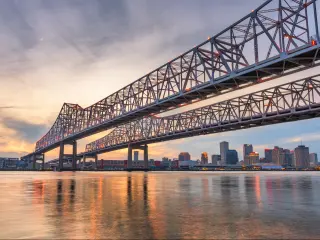 New Orleans, Louisiana, USA at Crescent City Connection Bridge over the Mississippi River at dusk.