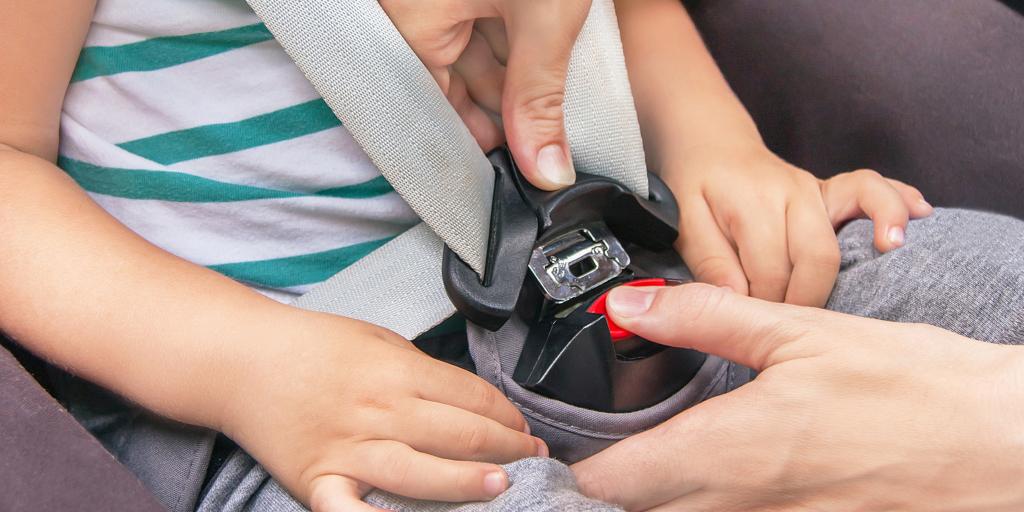 A parent fastening child's seatbelt