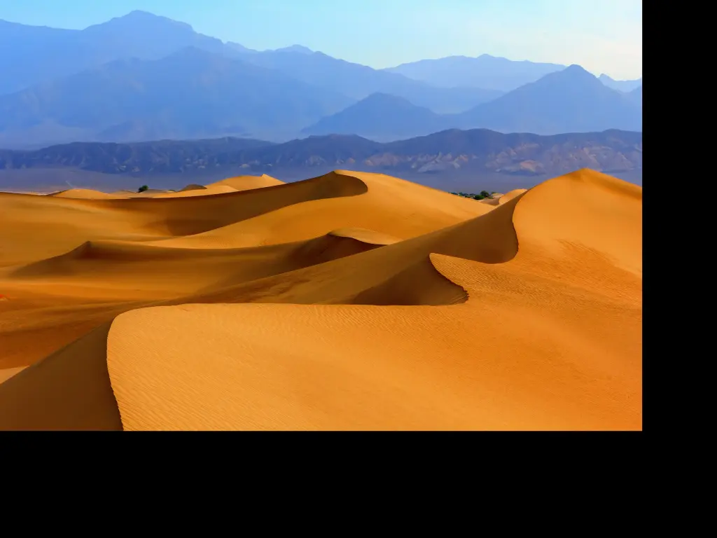 Sand dunes with mountains in the background in Death Valley National Park, California