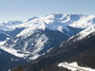 Snowcapped mountains in Colorado surrounding the pass on a hazy day
