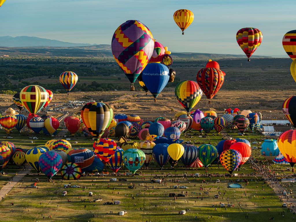 Albuquerque, New Mexico, USA with an aerial view of the hot air balloon mass ascension at the Albuquerque International Balloon Fiesta on a sunny day.