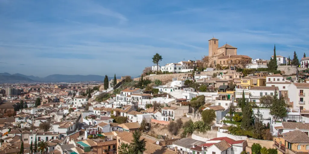 A view over the district of Albayzin, in Granada, Spain with lots of white and terracotta houses sprawling down the hillside