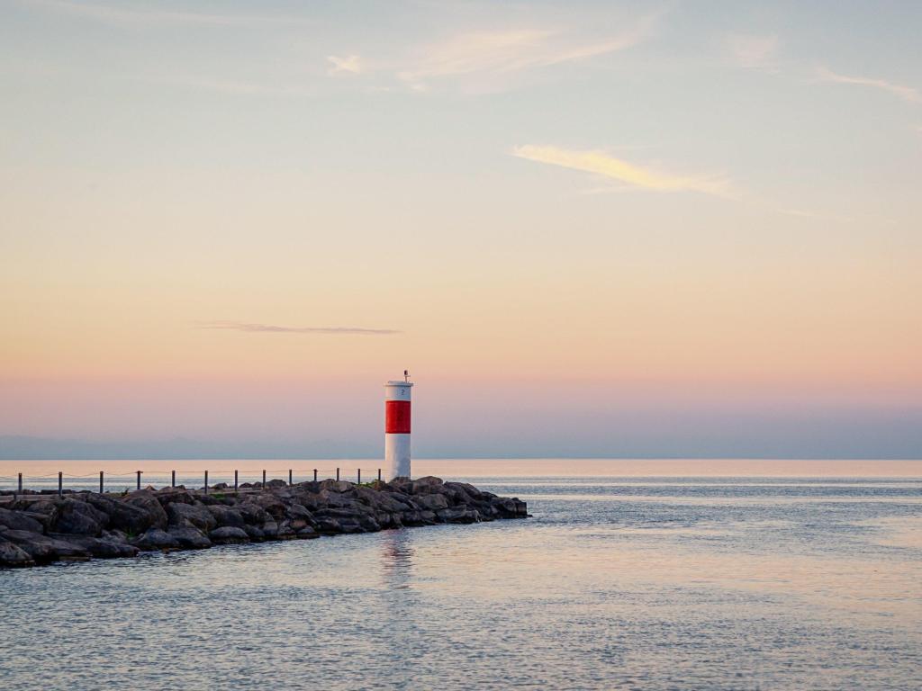 Lake Ontario, Rochester, USA with a lighthouse and beautiful pastel sunset taken around the shore of the lake. 