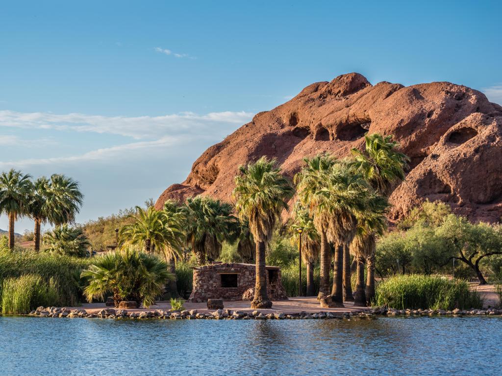 The Hole-in-the-Rock natural geological formation is visible from across one of Papago Park's ponds.