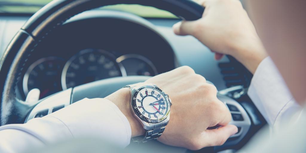 Man checking time behind steering wheel