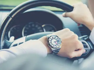 Man checking time behind steering wheel
