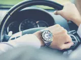 Man checking time behind steering wheel