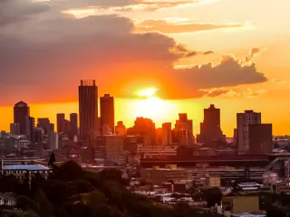 Fiery sunset behind the city's skyline, photo taken from a nearby hill