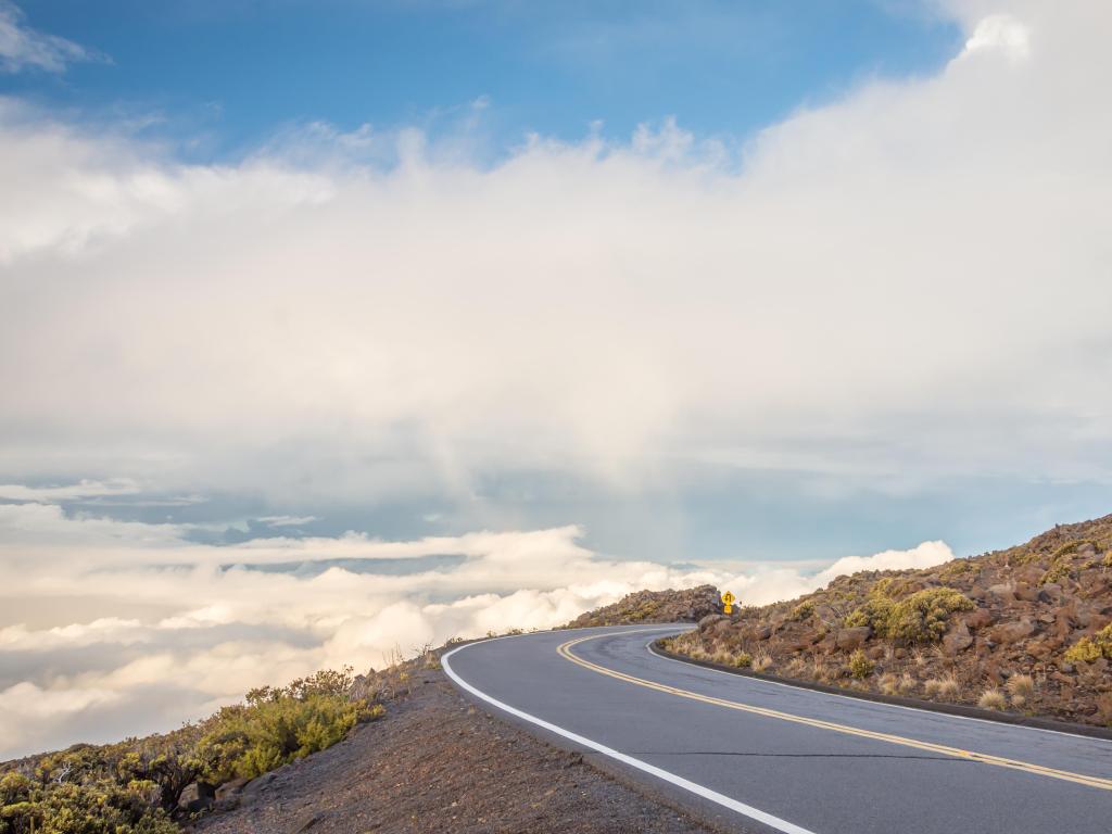 A winding mountain road high above the clouds, on the way to Haleakala on Maui, Hawaii.