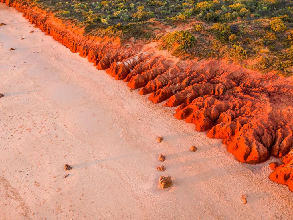 Red coastal cliffs of Riddell Beach in Broome, Western Australia at sunset