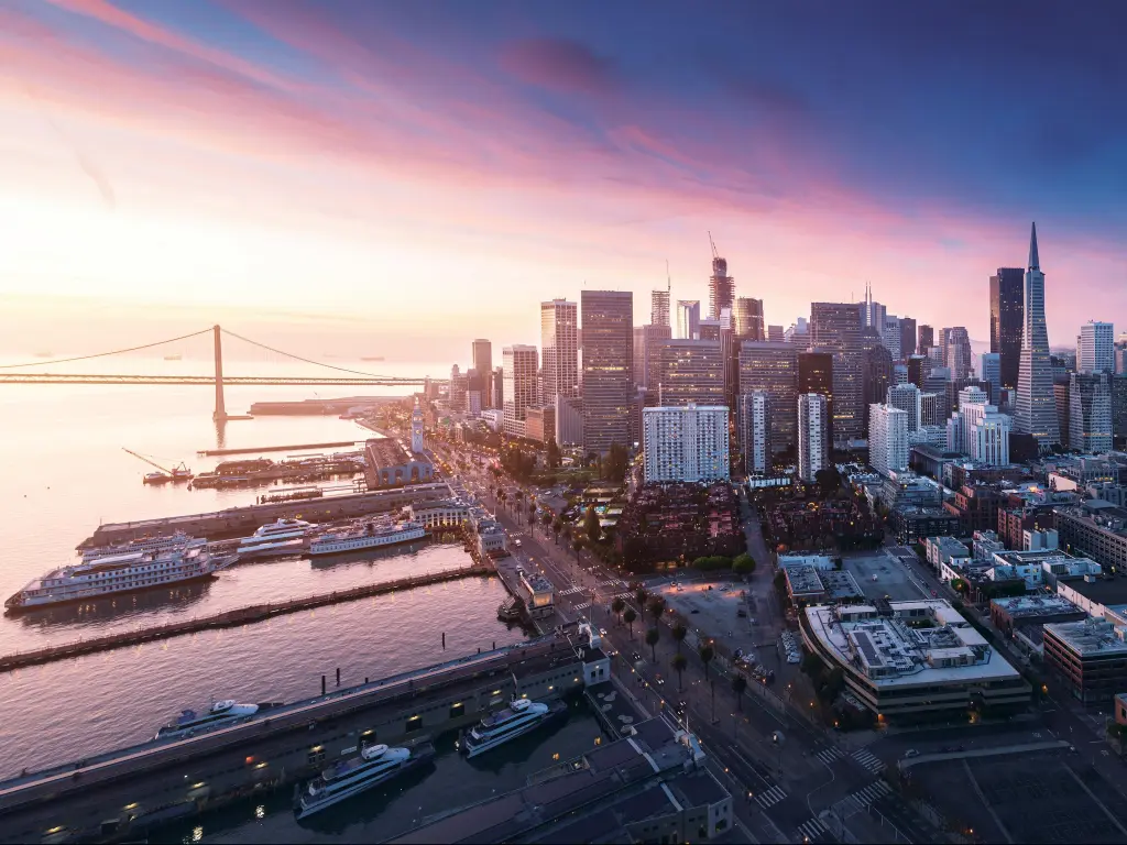 San Francisco, USA with a panorama view of the city at sunrise with the waterfront and downtown and bridge in the distance. 