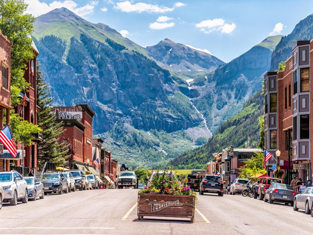 Telluride sign as you enter, surrounded by historic architecture on main street and mountain view in the background