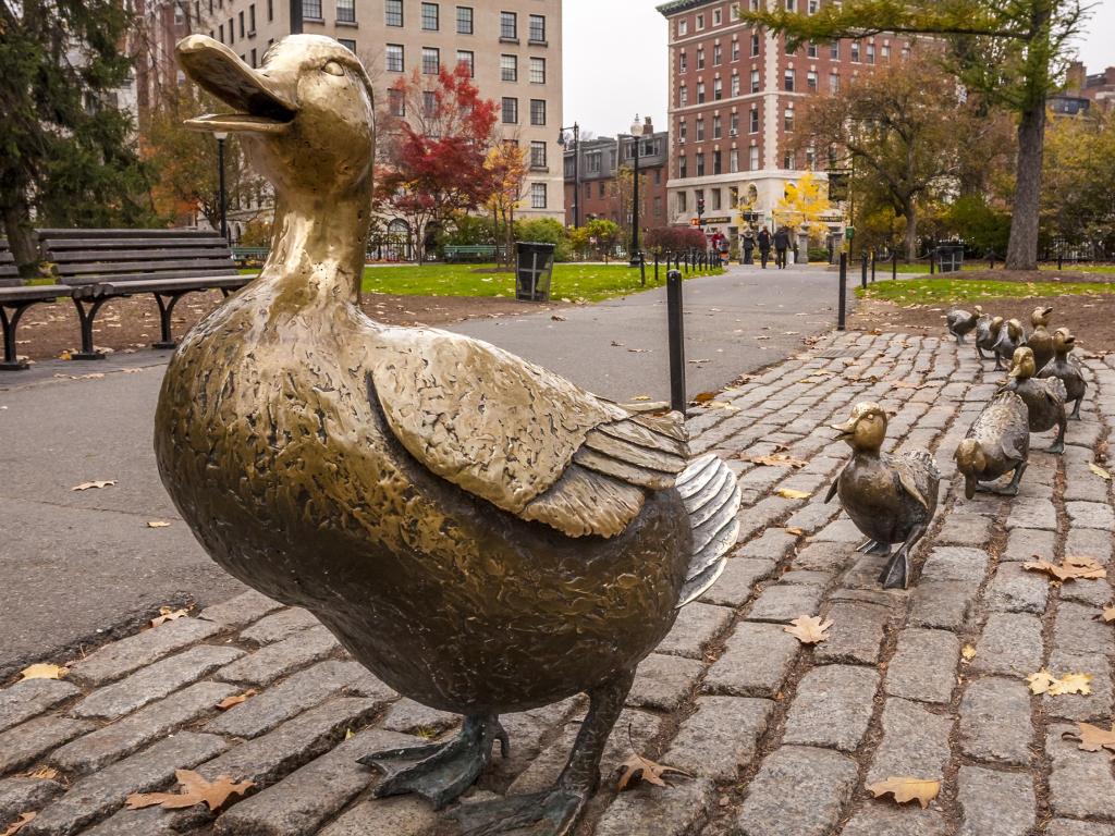 Panoramic view of Boston in Massachusetts, USA showcasing the Boston Public Garden with its famous duck family brass statues during the fall season.