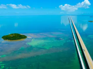 An aerial view of the straight 7 Seven Miles bridge on the Overseas Highway, Florida, with blue waters and reefs visible below the water