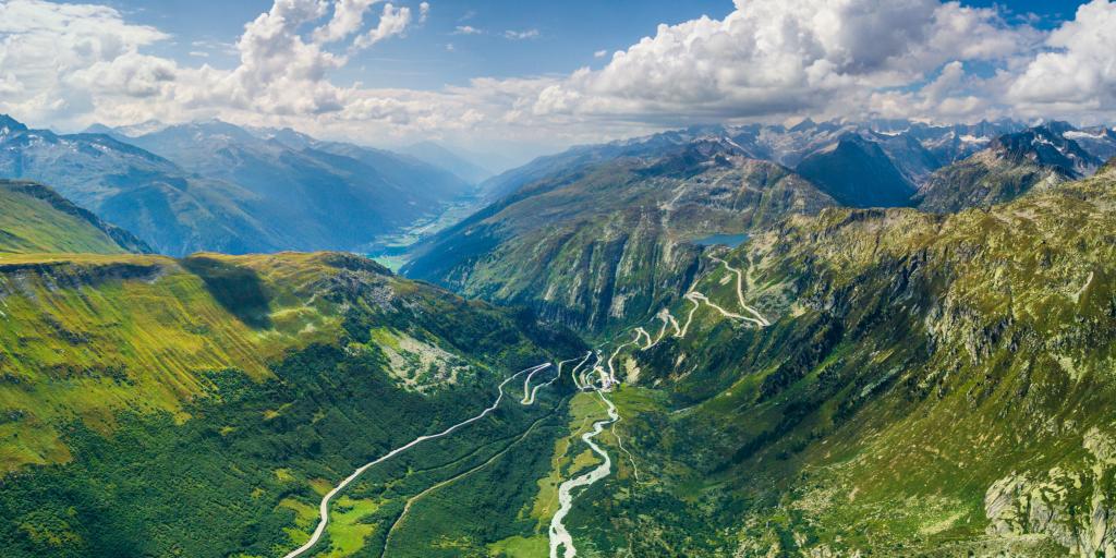 Aerial view of the Furka Pass hairpin bends on the green mountain side 