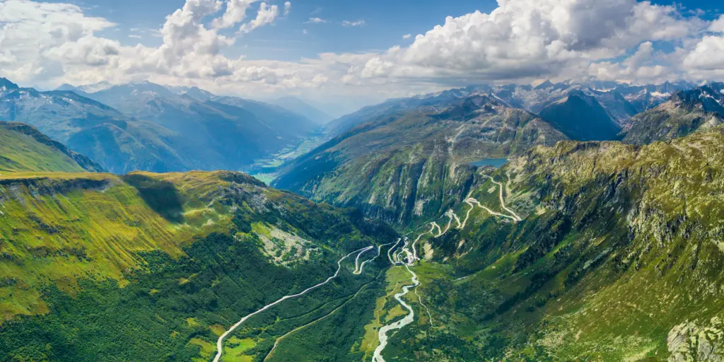 Aerial view of the Furka Pass hairpin bends on the green mountain side 