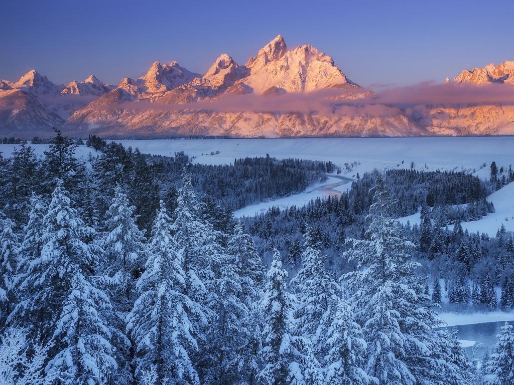 Winter sun rising over the Snake River Overlook in Grand Teton National Park, casting an orange glow