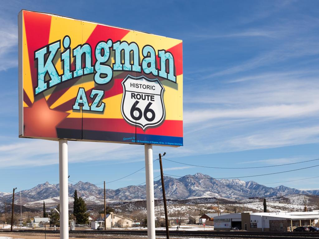 Colorful Route 66 sign in Kingman on a sunny day with mountains in the background