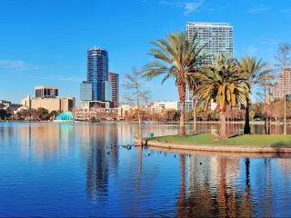 Orlando Lake Eola in the morning with urban skyscrapers and clear blue sky.