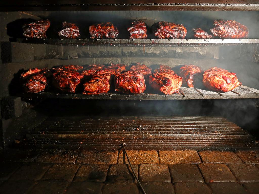 Pork being cooked in a southern style pit barbecue