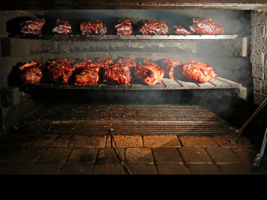 Pork being cooked in a southern style pit barbecue