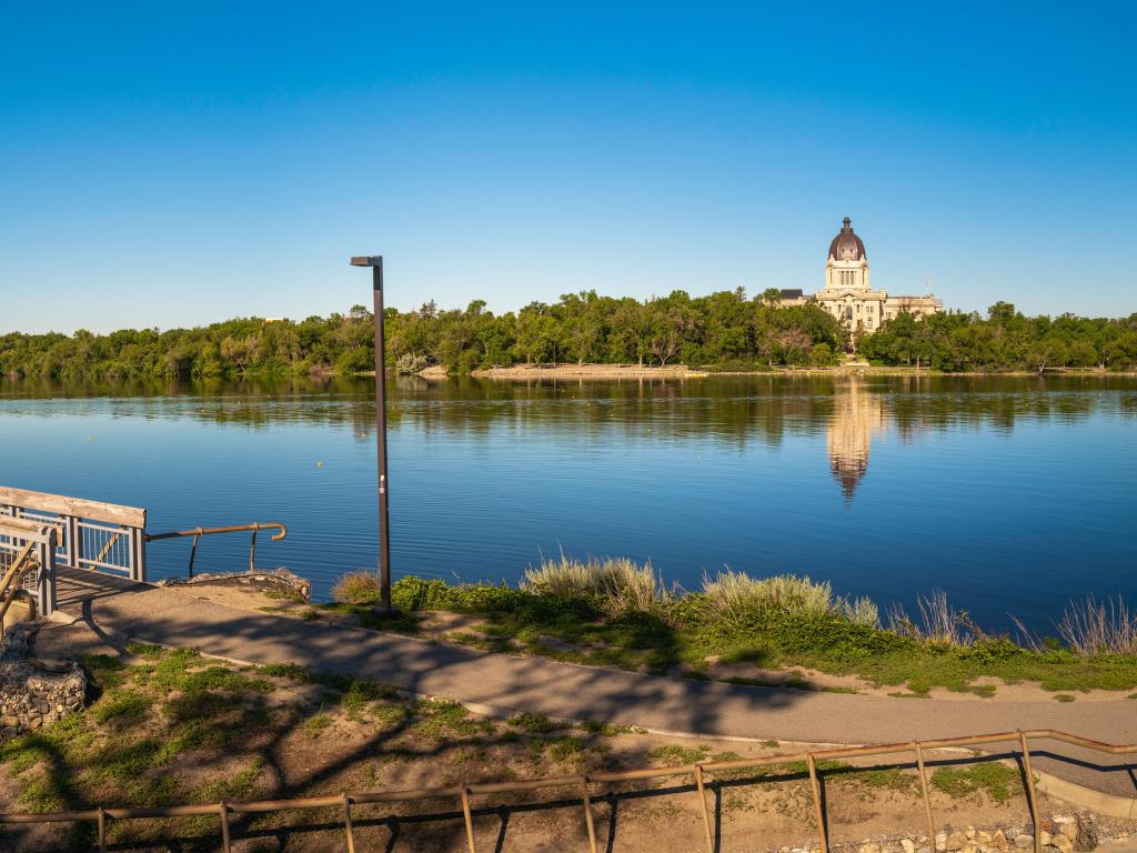 Tranquil Wascana Lake and the bridge along the walking trail of the lake park and view of the Saskatchewan Legislative Building, Regina, Saskatchewan, Canada