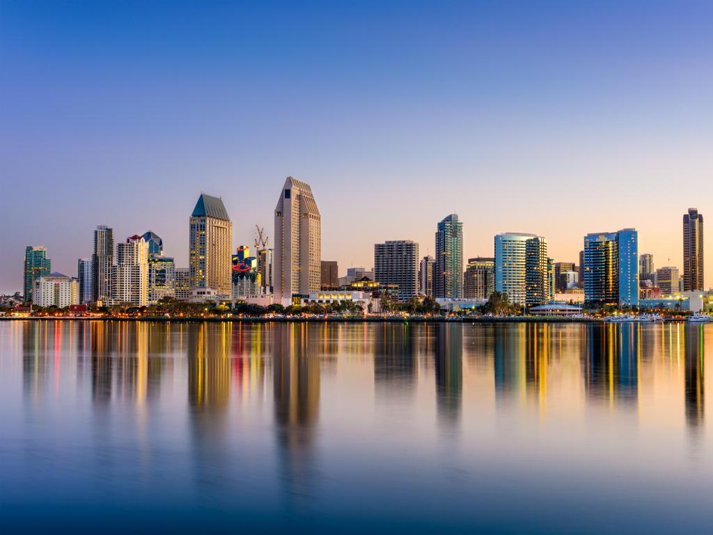 The downtown skyline at San Diego, California at sunset with its tall buildings reflecting in the water.