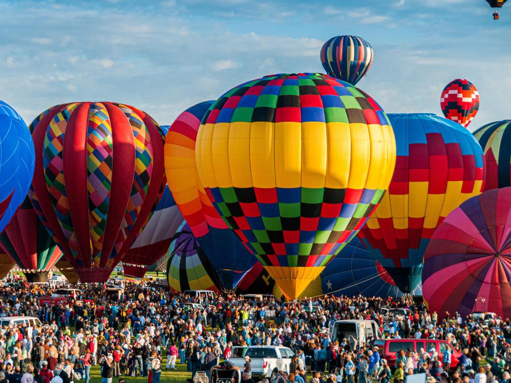 Huge crowds beneath dozens of ascending balloons at the Albuquerque International Balloon Fiesta