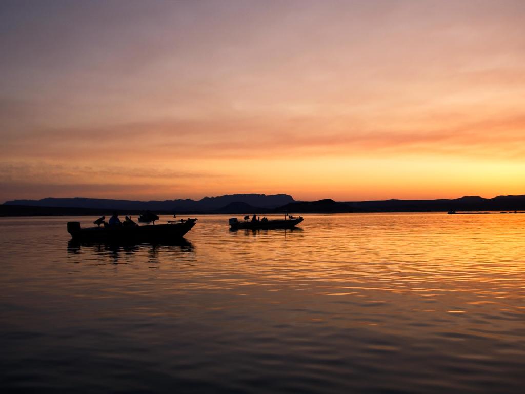 Silhouettes of two fishing boats in the water at sunset at Elephant Butte Reservoir