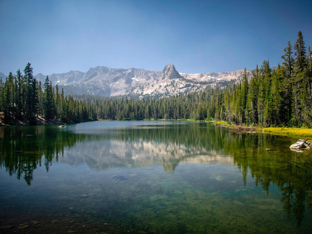 Horseshoe Lake, Mammoth Lakes, California in summer. Photo is taken on a clear day with blue skies and crystal-clear waters.