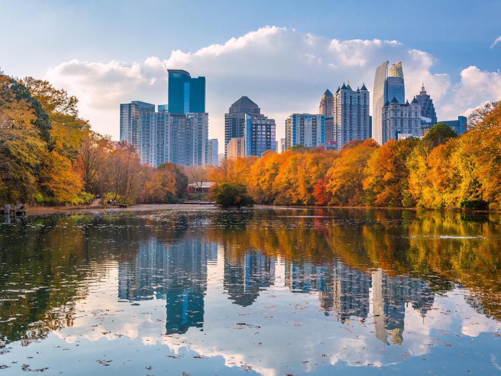 Atlanta, Georgia, USA taken at Piedmont Park skyline in fall on Lake Meer with the city reflecting on the waters edge and taken on a sunny day.