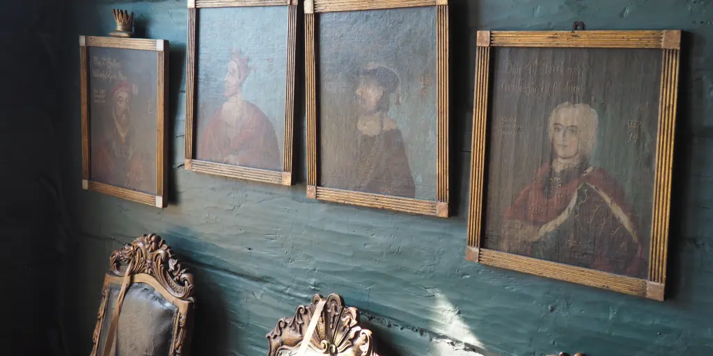 Portraits hanging on a dark green wall in the Hanseatic Museum of Bergen