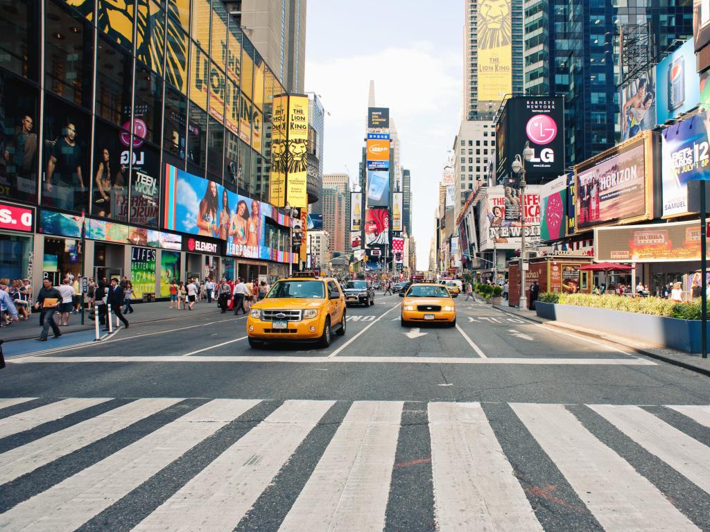 New York City, USA with taxi cars in Times Square, a busy tourist intersection of commerce Advertisements and a famous street of New York City.