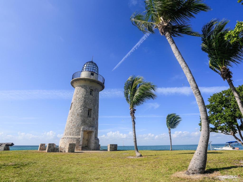 Biscayne National Park, Florida, USA at the remote Boca Chita Key, the 65 foot ornamental lighthouse taken on a sunny day with palm trees.