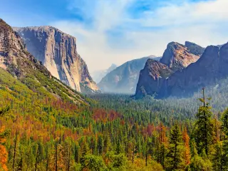 Tunnel View of scenic Yosemite Valley with famous El Capitan, Half Dome rock climbing summits, sunny day