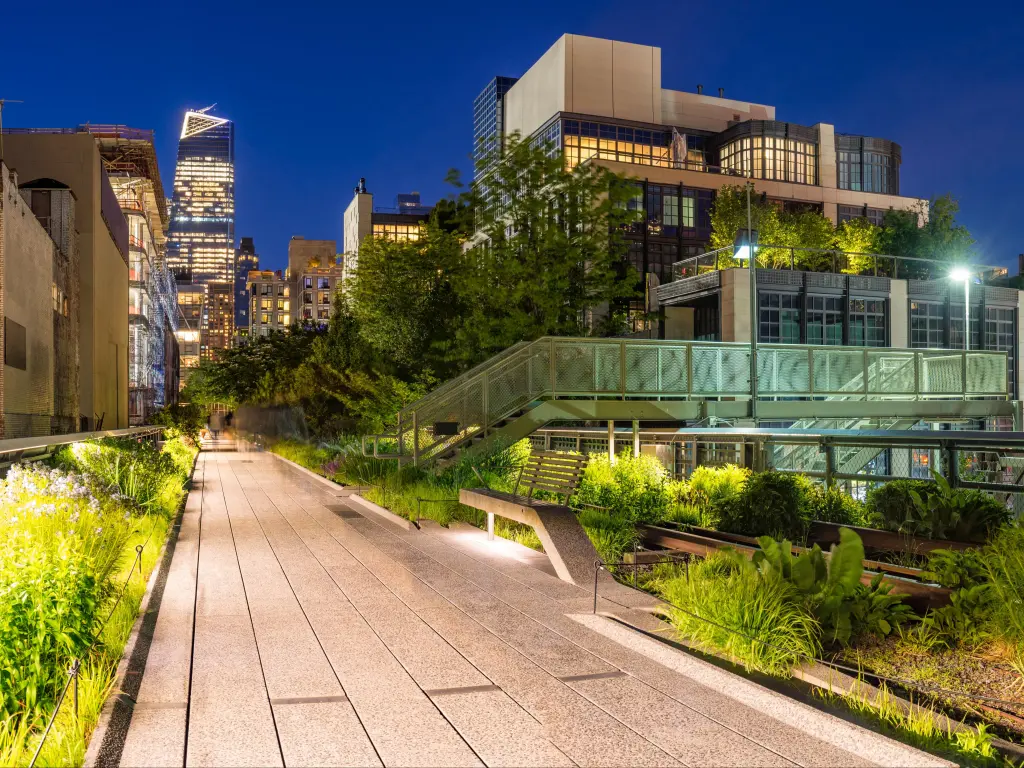 Panoramic view of the High Line promenade at twilight with city lights and illuminated skyscrapers