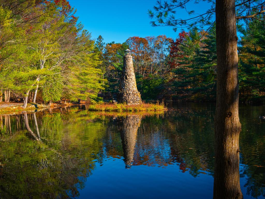 Duxbury Beach Park, Massachusetts, USA taken at a tranquil lake with green forest and lighthouse on a clear sunny day.