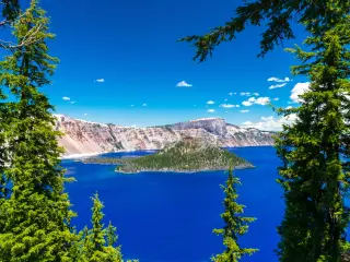 Bright blue lake , view framed by trees on a sunny day