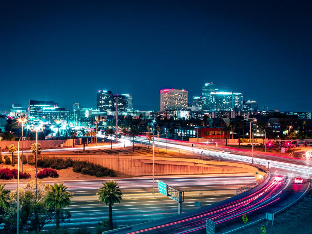 Freeway of Phoenix, Arizona during the night with the streetlights on and few cars on the roads.