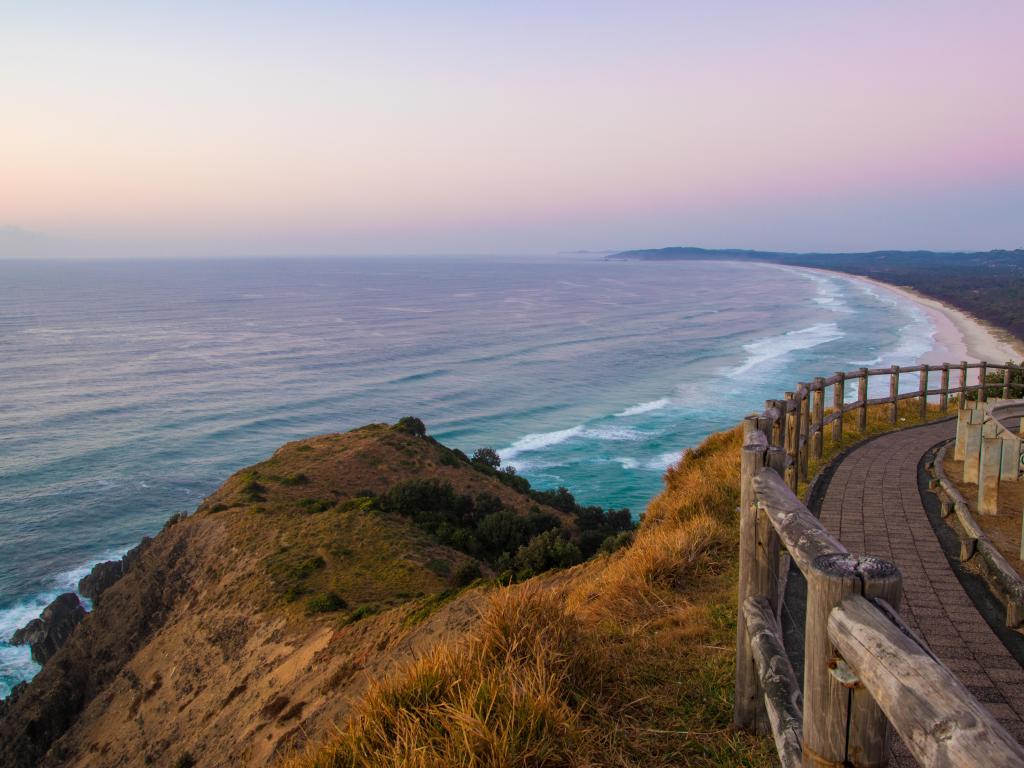 View down towards a wide sweeping sandy bay in early morning light