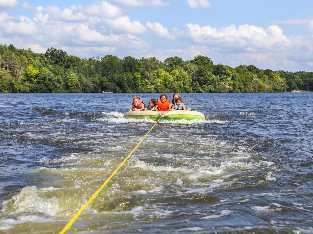 A group of children having fun, tubing on a calm blue lake