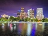 Los Angeles, California, USA with the downtown skyline taken at night and the city skyscrapers reflecting in the water in the foreground.