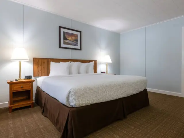 Interior of a spacious room with a bed and two bedside tables