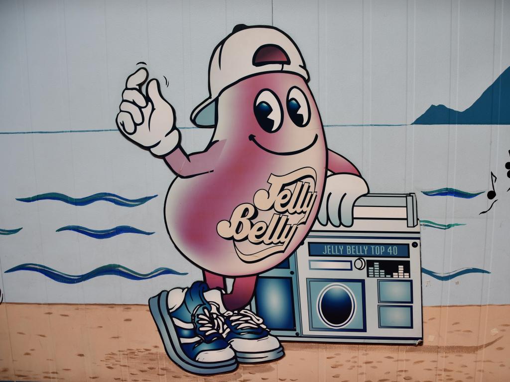 A drawing of a Jelly Belly candy bean with a boom box on the factory wall