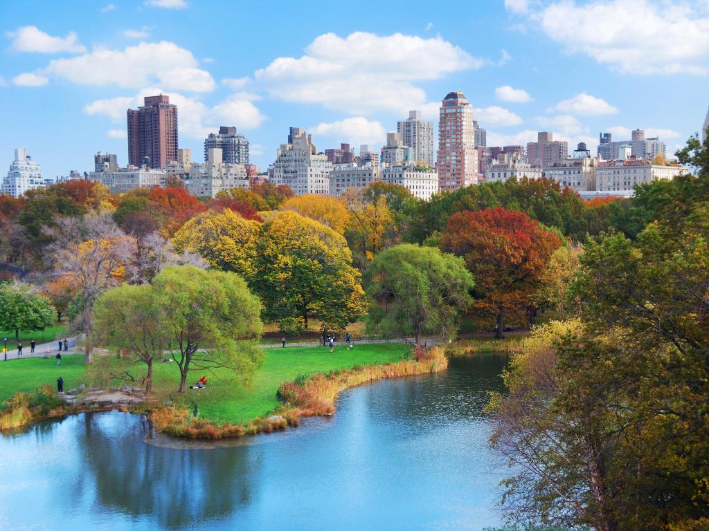 New York City Manhattan Central Park panorama in Autumn lake with skyscrapers and colorful trees with reflection.