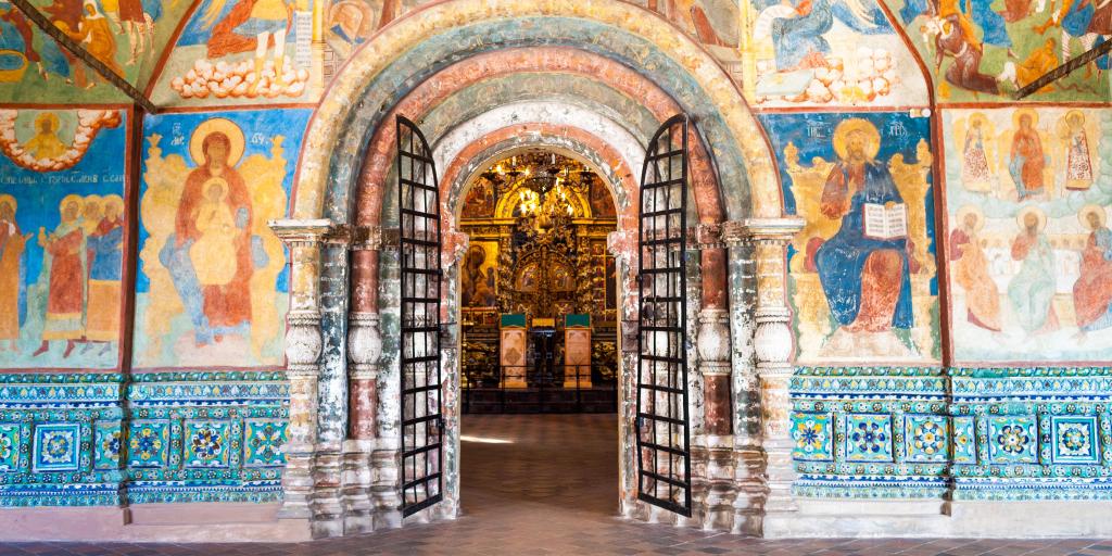 Arched internal doorway surrounded by colourful wall painting with icons in the Church of Elijah the Prophet in Yaroslavl, Russia